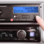 Finger pressing button on digital tachograph device